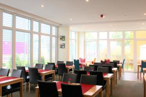 因戈尔施塔特康明茵酒店的用餐室设有桌椅和窗户。