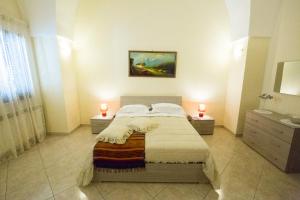 科佩尔蒂诺Casa Annette的一间卧室配有一张床、一个水槽和两个蜡烛