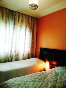 达布阿扎Perle de Tamaris的一间卧室设有两张床和一扇带灯的窗户