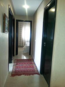达布阿扎Perle de Tamaris的走廊,门通往一间地毯的房间