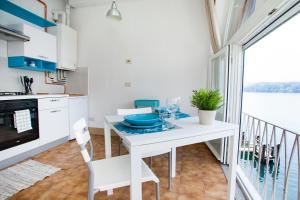 奥尔塔圣朱利奥-Ortaflats- Appartamento Gli Archi的一个带桌子的白色厨房和一个阳台