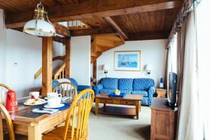 纽波特纽波特湾俱乐部酒店的客厅配有蓝色的沙发和桌子