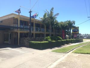 莱克斯恩特伦斯亚伯塔斯曼海滨汽车旅馆 的棕榈树和旗帜的街道上的建筑