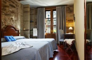 圣地亚哥－德孔波斯特拉比利亚尔街酒店的一间卧室配有一张带蓝色枕头的床。