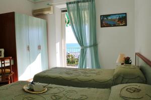 上阿尔比索拉Appartamenti Mare Azzurro by Holiday World的一间卧室设有两张床和窗户。
