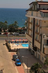 安塔利亚奥尔比亚公寓酒店的一座有汽车停放在游泳池旁的建筑