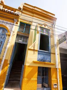 贝伦Hostel Amazonia的黄色的建筑,设有窗户和阳台