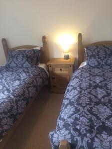 奥本An Teallach的一间卧室配有两张床和床头灯。