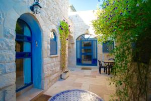 萨法德艺术区住宿加早餐旅馆的一个带蓝色门和桌椅的庭院