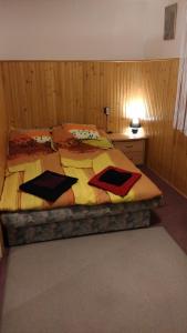 欧罗什哈佐Napsugár Vendégházikó的一间卧室配有一张大床,铺有黄色和红色的床单。