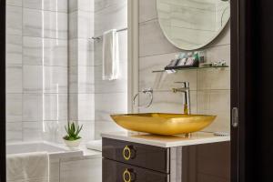 哈尔科夫米拉克斯蓝宝石精品酒店的浴室配有金色水槽和浴缸。