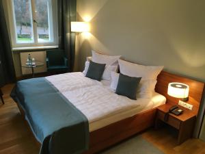 开姆尼茨拉本斯泰因城堡酒店的卧室配有一张带白色床单和枕头的大床。