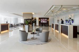 迪拜迪拜朱美拉罗塔纳酒店的大楼内带桌椅的大堂