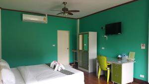 考索考索乡村度假村的一间卧室设有绿色的墙壁、一张床和一张书桌