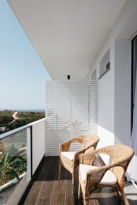 科武港O Lugar的阳台配有藤椅,享有海景。