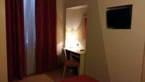 阿斯蒂Hotel Cavour的一间设有一张桌子的房间,墙上有一台电视机