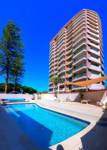 黄金海岸纳罗苑假日公寓的一座大型建筑,在一座建筑前设有一个游泳池