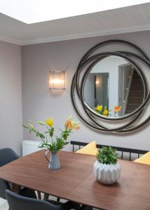 艾茅斯Albero Apartment的餐桌和墙上的圆镜子