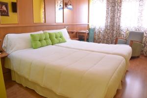 卡萨斯-伊瓦涅斯阿罗斯酒店 的卧室配有带绿色枕头的大型白色床