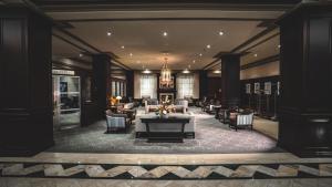 渥太华埃尔金王酒店的酒店大堂设有桌椅