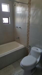 昆卡Casa Vacacional的浴室配有卫生间、浴缸和水槽。
