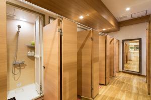 东京新宿区役所前胶囊酒店的设有带木墙的浴室内的步入式淋浴间