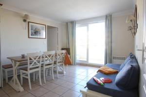 拉卡诺Residence Lacanau Bleu Marine - maeva Home的客厅配有蓝色的沙发和桌子