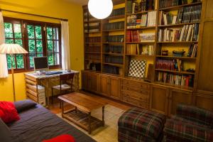 圣地亚哥－德孔波斯特拉Casa da Curuxeira的客厅配有书桌和书架