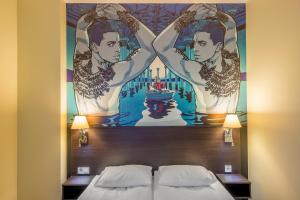 维尔纽斯LT - 摇滚乐维尔纽斯康福特酒店的一张位于酒店客房床铺上的壁画