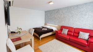 大戈里察梦幻酒店的客厅配有红色的沙发和床。