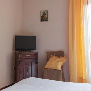 龙基德伊莱焦纳里B&B Borgo San Vito的一间卧室配有一张床、一台电视和一把椅子