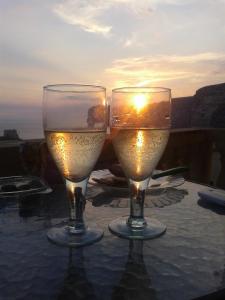 克伦蒂Palm Court Apartment的两杯酒坐在桌子上,欣赏日落美景