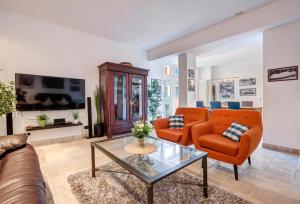 赛巴特班森Residenz Bellevue的客厅配有橙色椅子和玻璃桌