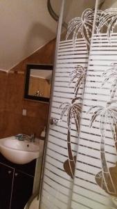 雅西Pensiunea Taverna Bucium的浴室设有棕榈树壁画和浴帘