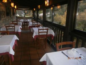 比盖特埃尔福恩旅馆的餐厅设有白色的桌椅和窗户。