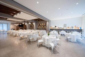阿尔塔穆拉富奥里勒穆拉酒店 的宴会厅配有白色的桌子和白色的椅子
