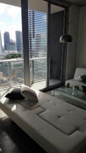 迈阿密Downtown Miami Deluxe Apartment的配有大窗户的客房内的白色床