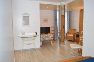 锡耶勒纪尧姆布列塔尼之家酒店的客厅配有桌椅和电视。