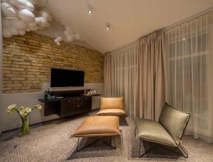 维尔纽斯阿塔格尼斯特艺术酒店的客厅配有两把椅子和电视