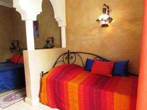 塔鲁丹特贾丹埃皮斯花园酒店的一间卧室配有一张带彩色毯子的床