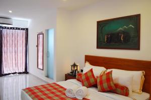 平纳瓦拉Cafe Pinnalanda的一间卧室配有红色和白色枕头的床