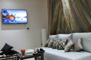 卡萨布兰卡Appartement Mogador的客厅配有沙发和墙上的电视