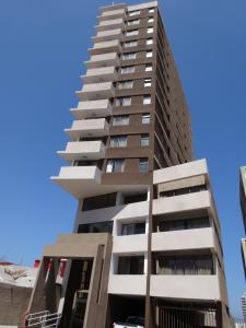 安托法加斯塔Tempora Apart Hotel的蓝色天空前方高耸的公寓楼