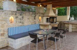 KiriánnaVilla Laga with Pool, 300m to Taverns, Childrens Area, BBQ!的庭院配有桌椅和壁炉。