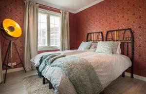 于韦斯屈莱Harmooni Suites的一间卧室设有一张红色墙壁和窗户的床