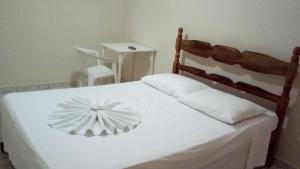 圣马特乌斯JB酒店的卧室配有白色的床和木制床头板