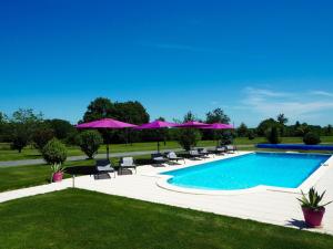 Saint-Pardoux-CorbierVillas de Leypinas B&B的一个带椅子和紫色遮阳伞的游泳池