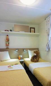 洛帕Mobile Homes Victoria San Marino的一间设有两张床的房间,床上有泰迪熊