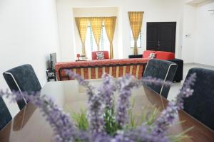 雪邦Warisan Indah Homestay KLIA 1的一间带桌椅和紫色鲜花的用餐室