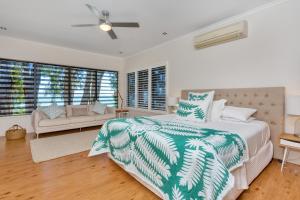 克利夫顿海滩海景豪华海滨度假屋的一间卧室配有一张床、一张沙发和窗户。